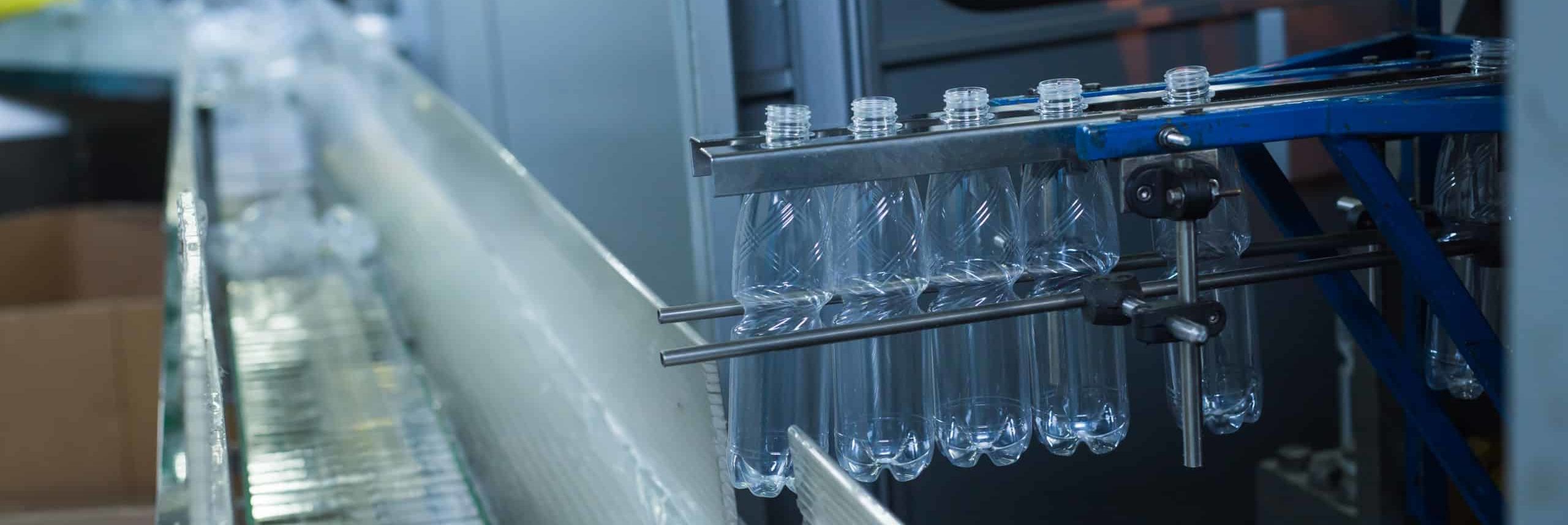 Plastic water bottles on conveyor and water bottling machine industry